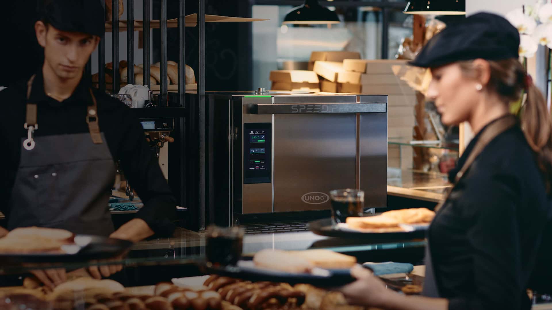 waitress serving sandwiches in front of a commercial speed oven