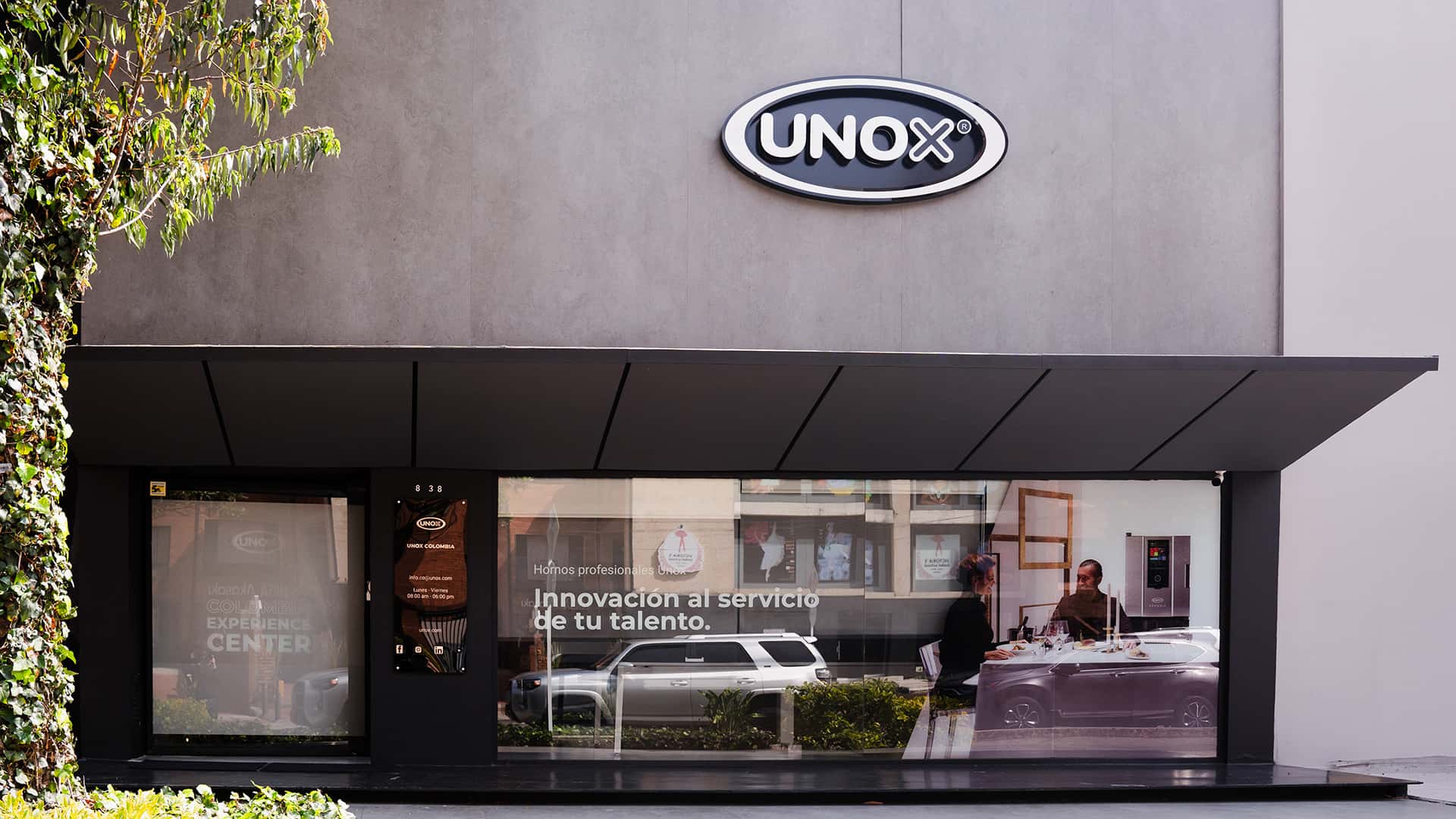 Large grey commercial building with Unox logo at the top. 'Colombia Experience Centre' is printed on the window. 