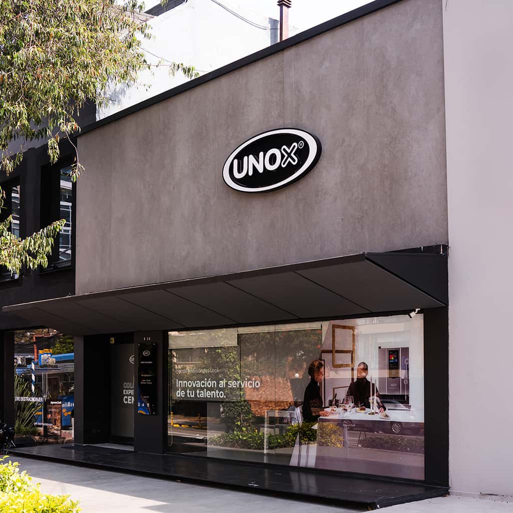 Large grey commercial building with Unox logo at the top. 'Colombia Experience Centre' is printed on the window. 