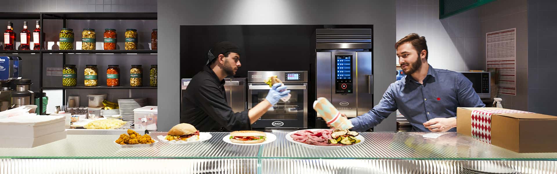 Operatori ristorante fast food lavorano davanti a forno professionale SPEED-X e mantenitore caldo EVEREO