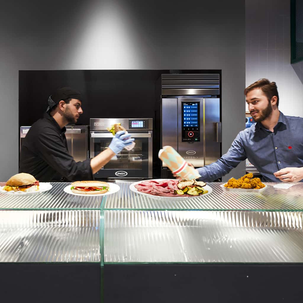 Operatori ristorante fast food lavorano davanti a forno professionale SPEED-X e mantenitore caldo EVEREO