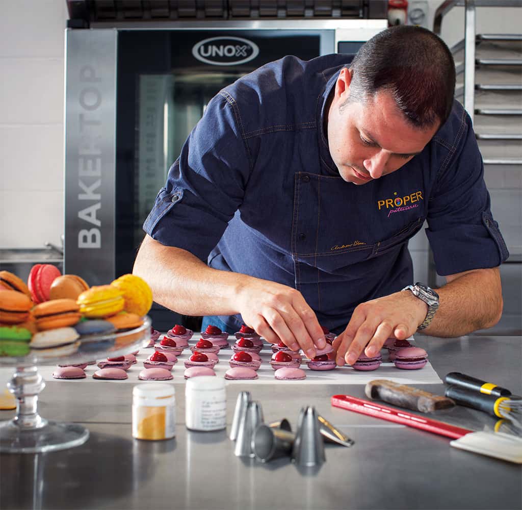Mandlig kok forbereder macarons foran en Unox BAKERTOP konditorovn