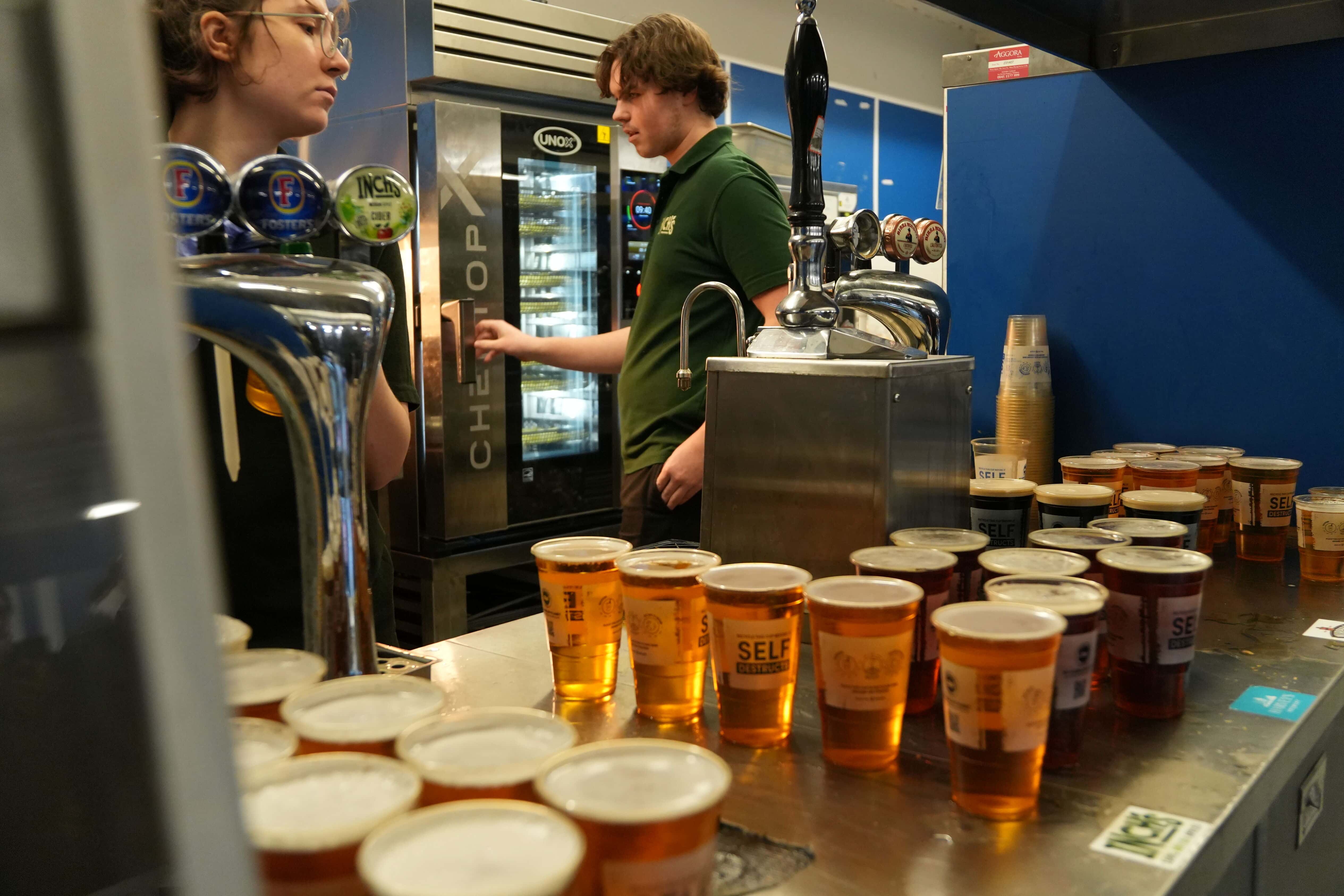Cucina da stadio con birre in primo piano e operatore che apre il forno combinato Unox chefto-x sullo sfondo