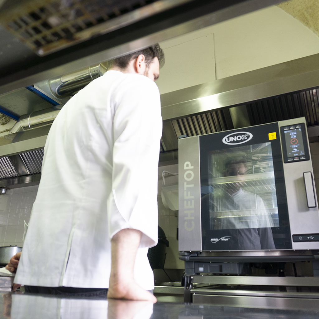 Executive chef in the kitchen who is using the commercial combi oven CHEFTOP MIND.Maps™ COUNTERTOP